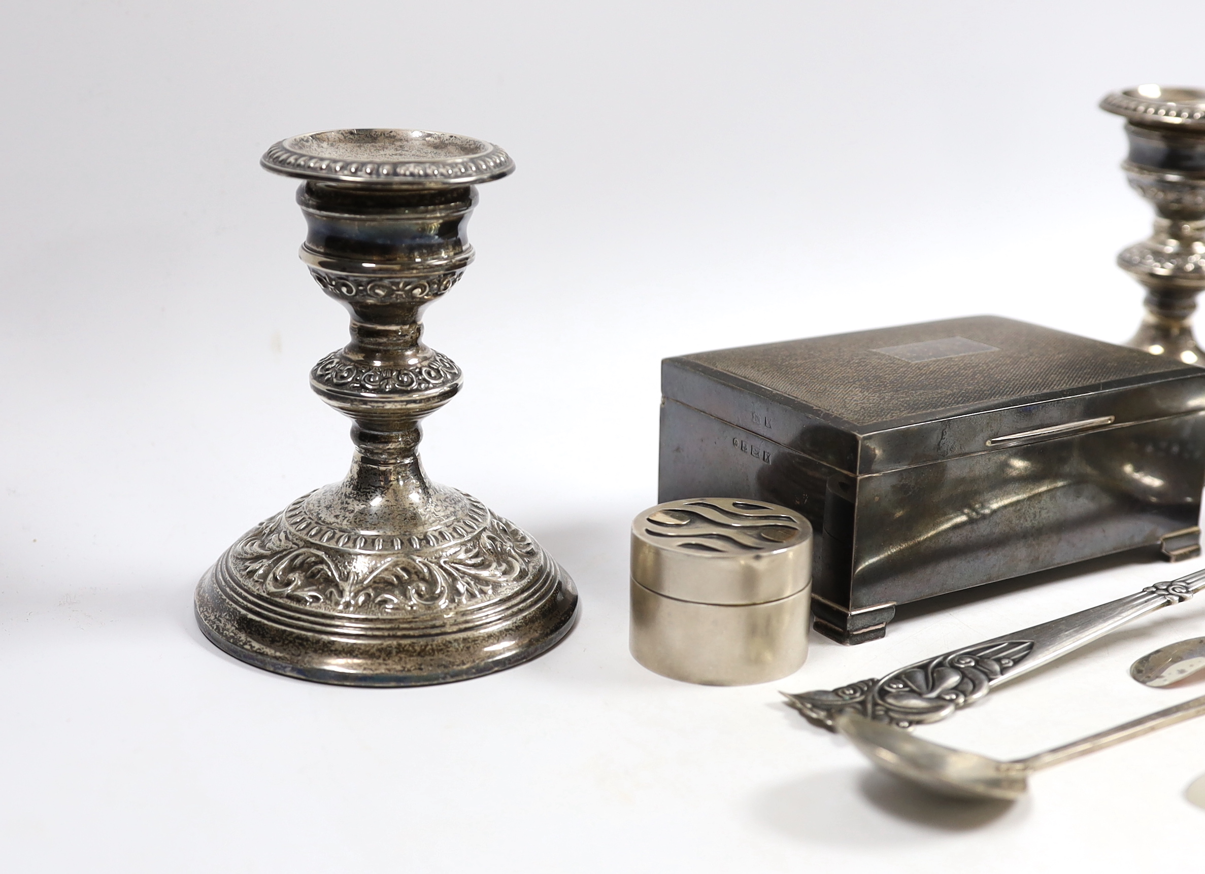 Sundry silver including a cigarette box, pair of dwarf candlesticks, modern silver circular pill box and three spoons, maker GR and a large early 20th century stylish Swedish white metal sifter ladle.